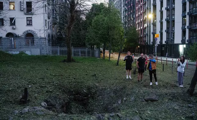 資料圖片：2026年5月24日，烏克蘭基輔盧基亞尼夫卡區，人們站在俄羅斯導彈襲擊造成的彈坑旁。（美聯社圖片/Evgeniy Maloletka） AP圖片