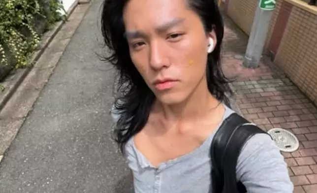 他穿灰色緊身上衣配黑色緊身褲，中分長髮配嫵媚神情，散發中性美感，與過往陽光型男判若兩人。