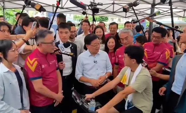 元州邨平台正有機構舉辦社區活動，現場放置智能健身單車，李家超與參加者傾談。巴士的報記者攝