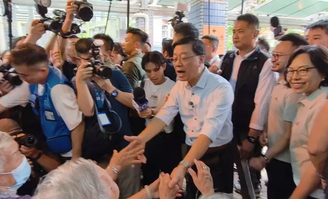 有市民上前與特首合照，亦有街坊希望李家超為民請命。巴士的報記者攝