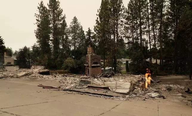 2026年8月2日周日，華盛頓州斯波坎W. Indian Trail Rd.一幢建築物被山火焚毀後，仍有小火焰持續燃燒。(美聯社圖片/Young Kwak) AP圖片