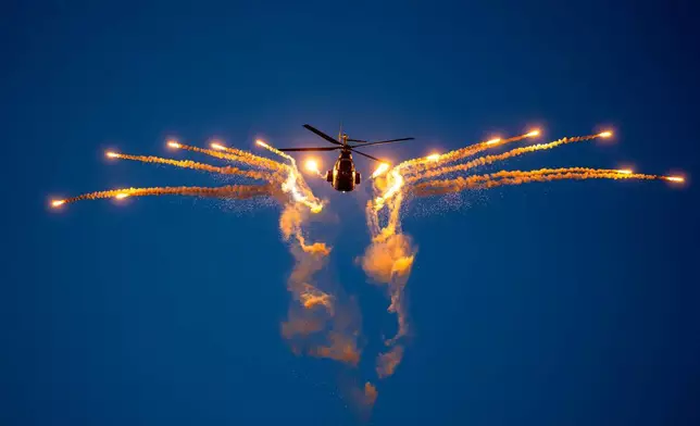 一架軍用直升機在羅馬尼亞布加勒斯特國際航空展期間發射照明彈。攝於2026年8月29日周六。(美聯社圖片/Andreea Alexandru) AP圖片