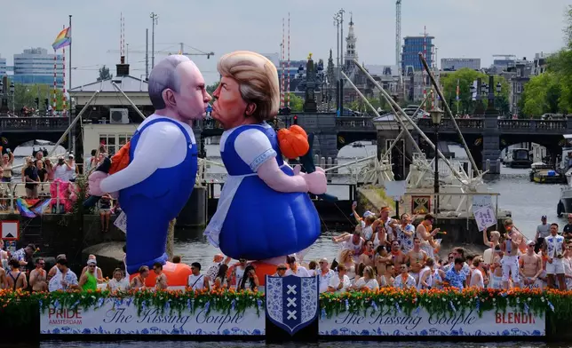 周六（2026年8月1日），美國總統特朗普（中）及俄羅斯總統普京（左）的兩個充氣漫畫氣球，在荷蘭首都的歷史運河上巡遊，吸引民眾圍觀阿姆斯特丹同志驕傲運河巡遊。(美聯社圖片/Patrick Post) AP圖片