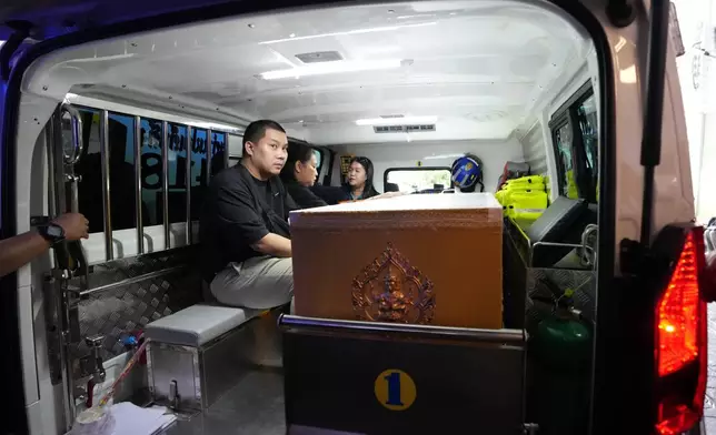 周六（二零二六年八月八日），泰國曼谷一間警署醫院內，一名親屬坐在救護車內，棺木載有周五德布西林暖武里學校槍擊案受害者的遺體。(美聯社圖片/Sakchai Lalit) AP圖片
