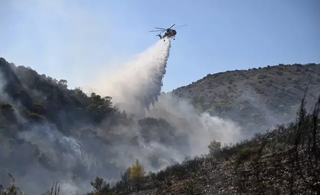 一架直升機周日（2026年8月16日）在希臘雅典以西的薩拉米納島，向山火灑水。(美聯社圖片/Michael Varaklas) AP圖片