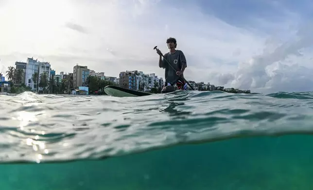 2026年6月27日，馬爾代夫呼魯馬累海岸外，來自呼魯馬累「Aloha Ufaa」衝浪俱樂部的一名衝浪者，與青年組織「Ripple」一同參與水底垃圾清潔活動。(美聯社圖片/Sophia Nasif) AP圖片