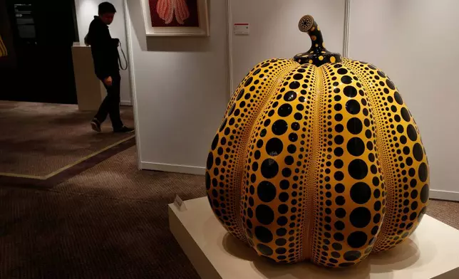 檔案圖片：2012年11月23日周五，香港羅芙奧拍賣會預展上，一名男子走過日本藝術家草間彌生的作品《南瓜》。(美聯社圖片/Vincent Yu) AP圖片