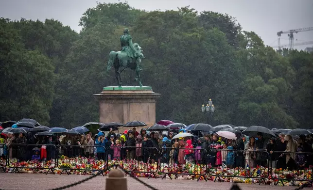 2026年8月28日周五，哀悼者在大雨中聚集，觀看哈拉爾五世國王的遺體運抵挪威奧斯陸王宮。(美聯社圖片/Heiko Junge/NTB) AP圖片