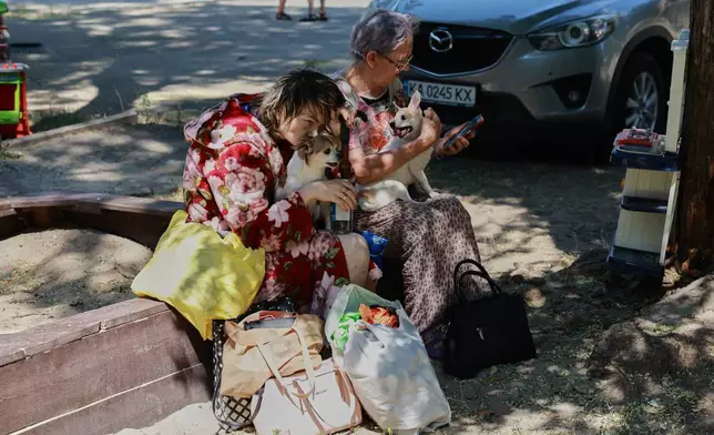 俄羅斯空投導彈擊中烏克蘭扎波羅熱並損毀其家園後，當地居民周一（2026年8月10日）與他們的狗坐在一起。(美聯社圖片/Kateryna Klochko) AP圖片