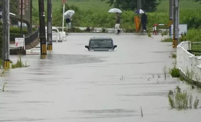 2026年8月27日周四，日本富山縣冰見市，一輛汽車被遺棄在因暴雨而水浸的街道上。(Suo Takekuma/共同社圖片/美聯社) AP圖片
