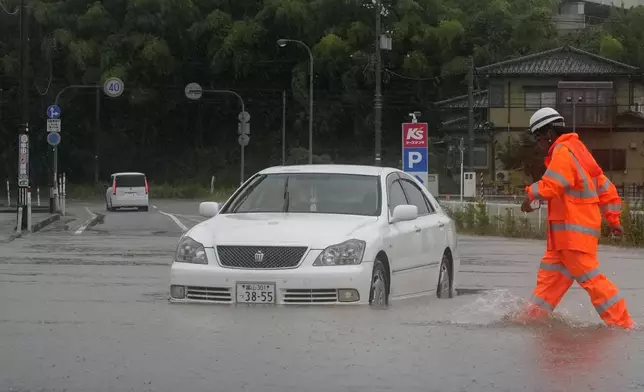 周四（2026年8月27日），日本富山縣冰見市，一輛汽車被遺留在因暴雨而水浸的街道上。(美聯社圖片/Suo Takekuma/共同社) AP圖片