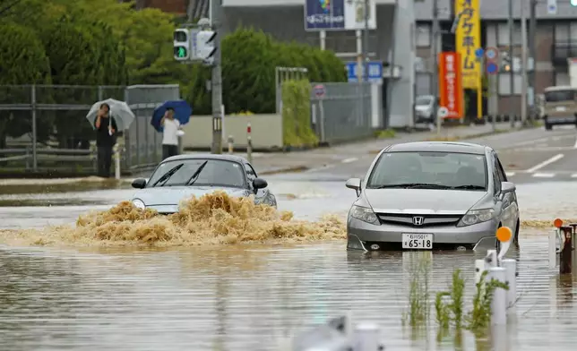 2026年8月27日周四，日本石川縣羽咋市，車輛駛過因暴雨而水浸的道路。(Yusuke Ogata/共同社圖片/美聯社) AP圖片
