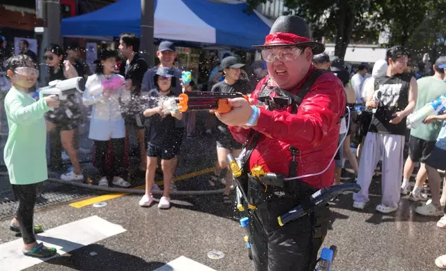 2026年8月8日周六，參加者在南韓首爾的水槍節期間用手上的水槍噴水。(美聯社圖片/Lee Jin-man) AP圖片
