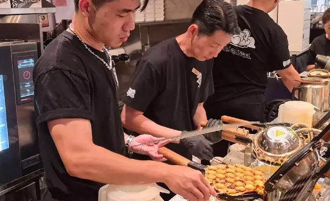 Chicken Egg Boy 專業團隊正在店內精心製作菠蘿包雞蛋仔。巴士的報記者攝