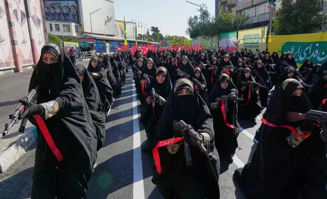 周五（2026年9月18日），在伊朗德黑蘭舉行的政府組織「Janfada」或「為伊朗犧牲」軍事式遊行期間，隸屬伊朗革命衛隊的女性成員持步槍站立。(美聯社圖片/Vahid Salemi) AP圖片