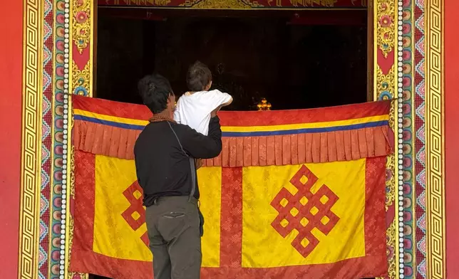一名倖存者在尼泊爾加德滿都一間佛寺內抱起其孩子。攝於2026年8月31日周一。(美聯社圖片/Niranjan Shrestha) AP圖片