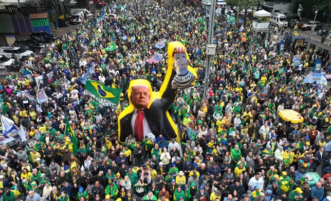 巴西聖保羅舉行獨立日活動，反對派總統候選人弗拉維奧博爾索納羅的支持者遊行，手持美國總統特朗普的肖像，肖像抱著一個描繪巴西總統盧拉達席爾瓦為囚犯的玩偶，攝於2026年9月7日周一，距離大選還有一個月。(美聯社圖片/Andre Penner) AP圖片