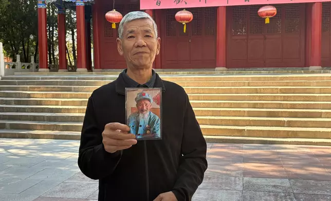 何芳軍展示父親何德林的照片。巴士的報記者攝