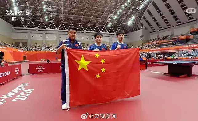 林詩棟(中)、黃友政(右)奪得亞運乒乓男雙金牌，賽後和主教練王皓(左)手持國旗合照。央視圖片