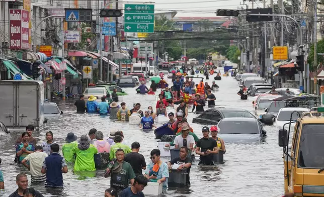 2026年9月28日周一，泰國曼谷，大雨過後，民眾涉水穿過被淹浸的街道。(美聯社圖片/Sakchai Lalit) AP圖片