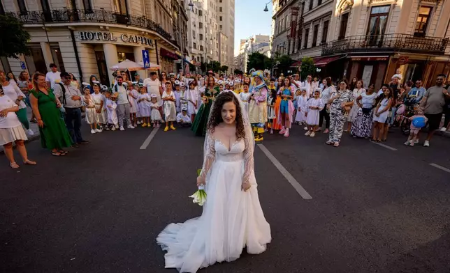 一名新娘與打扮成天使的兒童合照，他們在羅馬尼亞布加勒斯特參與小天使巡遊。這次巡遊是一個基督教主題街頭表演，有數十名兒童穿上天使服裝。攝於2026年9月5日周六。(美聯社圖片/Andreea Alexandru) AP圖片