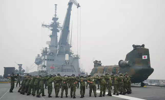 二零二六年九月十日周四，日本登陸艦「國東號」抵達印尼西加里曼丹孟巴哇的基京港後，甲板上的船員在山火霧霾中聚集。(美聯社圖片/Tatan Syuflana) AP圖片