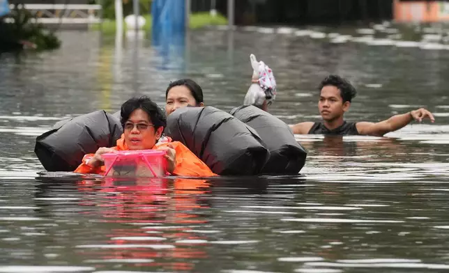 2026年9月27日周日，泰國曼谷民眾在暴雨過後涉水而行。(美聯社圖片/Sakchai Lalit) AP圖片