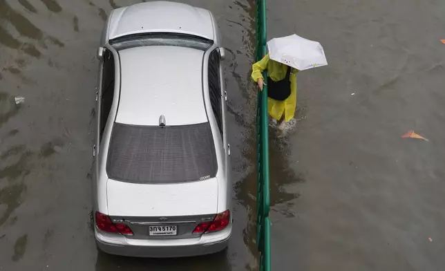 一名女子於2026年9月26日周六，在泰國曼谷暴雨後涉水而行。(美聯社圖片/Sakchai Lalit) AP圖片