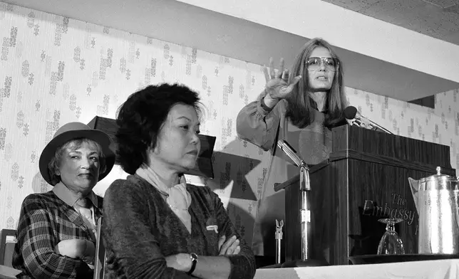 檔案照片：1979年11月21日，美國婦女組織的貝拉·阿布祖格（左）及帕齊·明克，在華盛頓坐在格洛麗亞·斯坦能旁邊聽她發言。(美聯社圖片/哈維·喬治斯 檔案照片) AP圖片