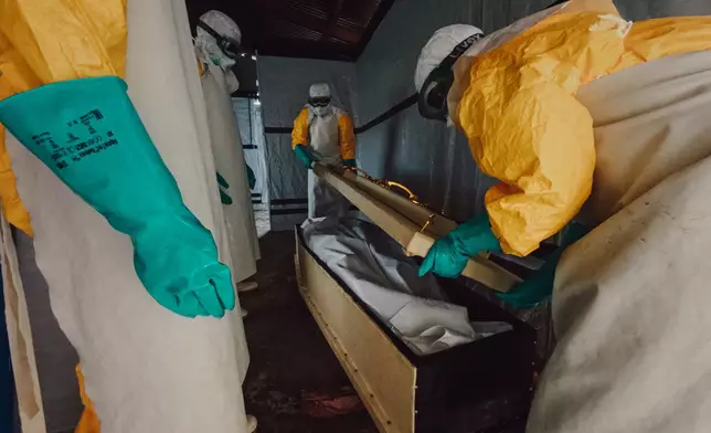 由於伊波拉病毒可透過接觸感染者的遺體傳播，安全且有尊嚴的安葬是減低病 毒傳播的重要措施。圖中的安葬團隊工作時，需要穿上全套防護裝備，按照嚴格程序 處理和安放遺體，並在棺木送往安葬前完成消毒程序。在防止病毒傳播的同時，亦讓 逝者獲得有尊嚴的安葬。