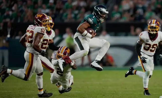 2026年9月13日周日，在費城舉行的一場美式足球聯盟（NFL）賽事下半場，費城老鷹隊四分衛傑倫·赫茨（1號）在跑動時，被華盛頓指揮官隊角衛阿米克·羅伯遜（2號）攔截。(美聯社圖片/Matt Slocum) AP圖片