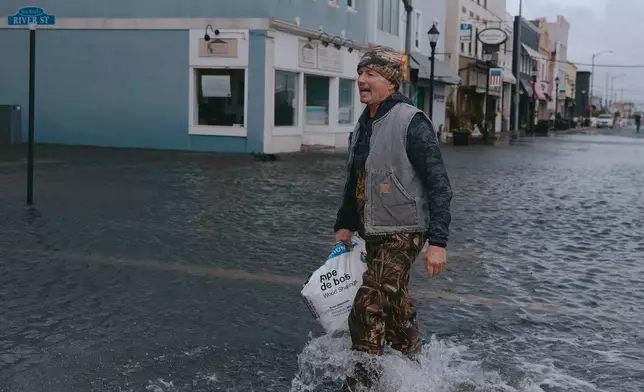 伯納德·道德於2026年9月27日周日，在新澤西州海布賴特，在東北風暴期間走在被水浸的街道上。(美聯社圖片/Andres Kudacki) AP圖片