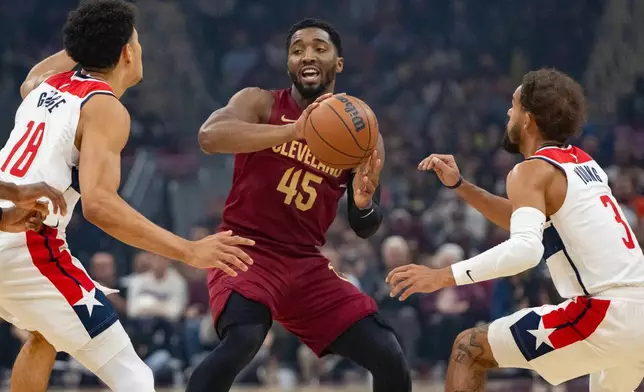 克里夫蘭騎士的米曹（45號）周三（2026年10月28日）在克里夫蘭舉行的NBA籃球賽上半場，在華盛頓巫師的佐治（18號）及楊格（3號）之間尋找傳球機會。(美聯社圖片/Phil Long) AP圖片