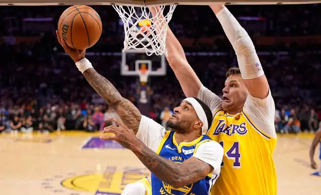 2026年10月21日周三，金州勇士後衛加利佩頓二世（左）在洛杉磯一場NBA籃球賽上半場射球，洛杉磯湖人中鋒禾加基斯拿防守。(美聯社圖片/Mark J. Terrill) AP圖片