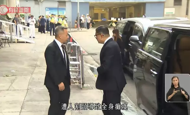 高級警員朱振國在紅磡世界殯儀館設靈，保安局局長鄧炳強(右)到場致意。有線新聞視頻截圖