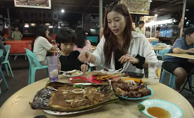 兩母子一抵埗便幫襯路邊攤，靠把口認識馬來西亞。