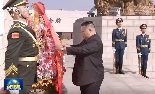 金正恩整理花牌。央視截圖