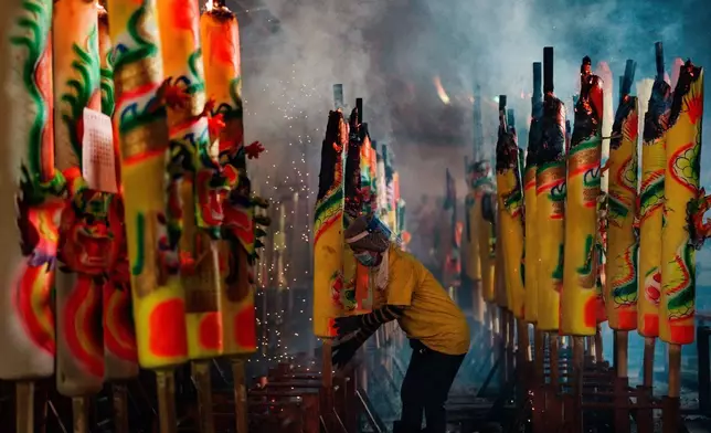 一名工人於2026年10月16日周五，在馬來西亞雪蘭莪安邦的九皇爺廟九皇爺誕期間，在濃煙中整理巨型香燭。(美聯社圖片/Vincent Thian) AP圖片