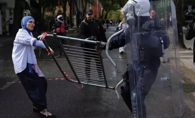 一名示威者拉動路障的一端，而一名警員則拉動另一端，攝於2026年10月15日周四，阿爾巴尼亞地拉那的反政府示威中。(美聯社圖片/Hameraldi Agolli) AP圖片