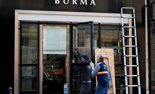 法國巴黎，工人在一間商店安裝防護設施，當地周六（二零二六年十月三十一日）將舉行抗議生活成本及教育問題的示威。(美聯社圖片/Emma Da Silva) AP圖片