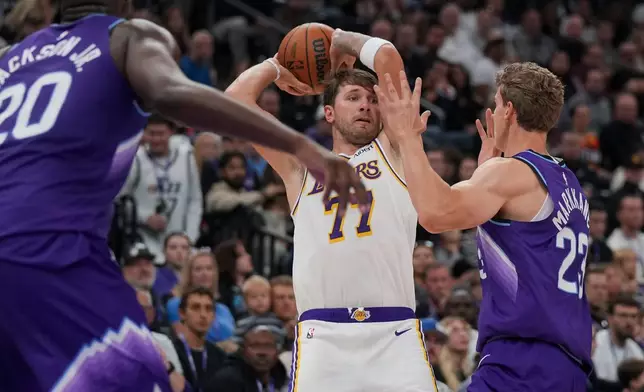 洛杉磯湖人前鋒/後衛盧卡當錫（77號）在NBA籃球賽上半場傳球，猶他爵士前鋒/中鋒勞里馬爾卡寧（23號）防守。比賽於2026年10月25日周日在鹽湖城舉行。(美聯社圖片/Bethany Baker) AP圖片