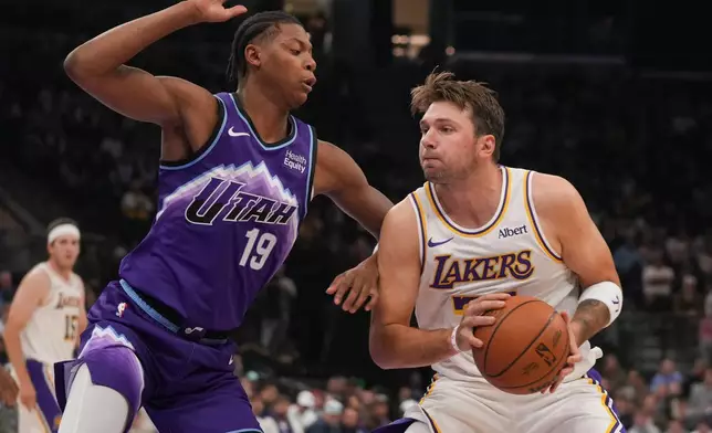 洛杉磯湖人前鋒/後衛盧卡當錫（77號）在NBA籃球賽上半場傳球，猶他爵士前鋒艾斯貝利（19號）防守。比賽於2026年10月25日周日在鹽湖城舉行。(美聯社圖片/Bethany Baker) AP圖片