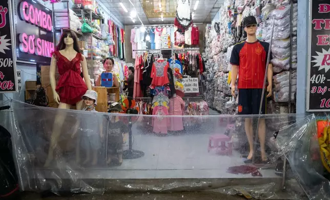 一名女子設置塑膠屏障以阻擋水浸進入店舖，大雨及漲潮導致越南胡志明市Pham Huu Lau街於2026年9月30日周三發生水浸。(美聯社圖片/Thanh Hue) AP圖片