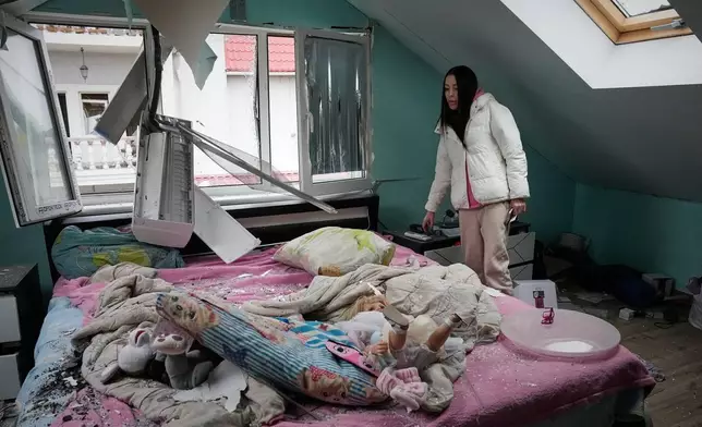 一名女子望向2026年10月22日周四在烏克蘭基輔遭俄羅斯導彈襲擊後受損的公寓。(美聯社圖片/Efrem Lukatsky) AP圖片