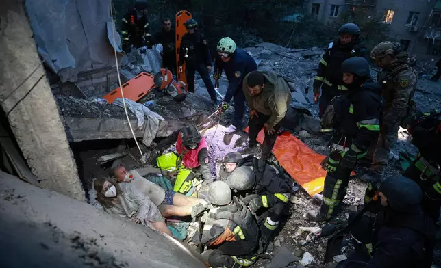 烏克蘭扎波羅熱一幢住宅大廈周六遭俄羅斯空襲摧毀，救援人員從瓦礫中救出一戶家庭。(美聯社圖片/Kateryna Klochko) AP圖片