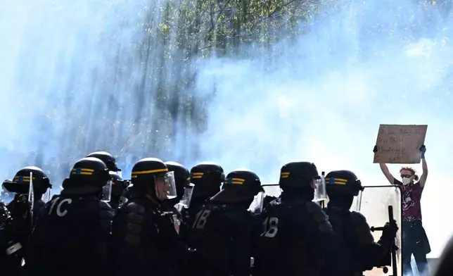 巴黎，周六（2026年10月17日），一名示威者在一場抗議生活成本上漲並響應學生訴求的示威活動期間手持標語。(美聯社圖片/Emma Da Silva) AP圖片