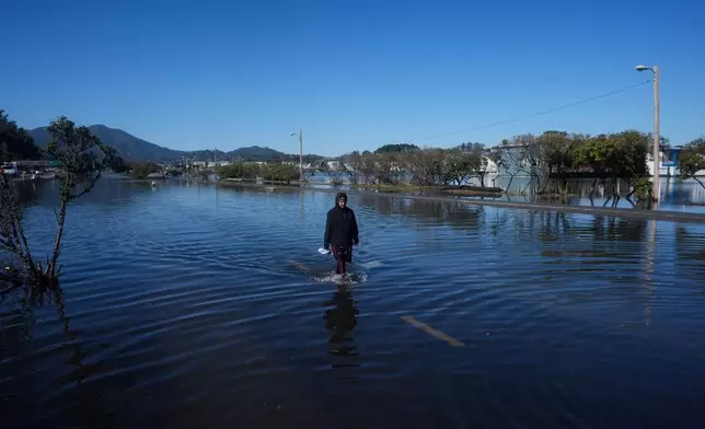 周三（2026年10月28日），一名女子在加州索薩利托一條水浸的道路上涉水而行。 (美聯社圖片/Jeff Chiu) AP圖片