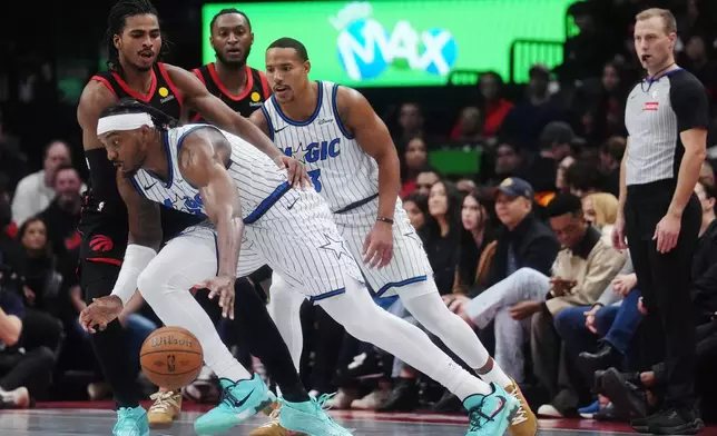 奧蘭多魔術隊的溫德爾卡特（前）在周五於多倫多舉行的NBA盃籃球賽上半場，運球突破多倫多速龍隊的科林穆雷-博伊爾斯（左上）。 (美聯社圖片/Nathan Denette/The Canadian Press) AP圖片