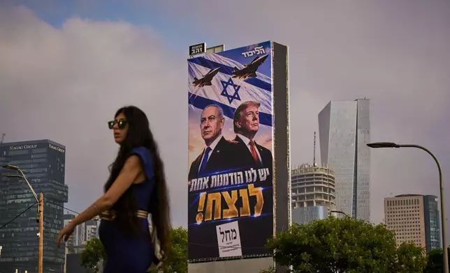 (美聯社圖片/Oded Balilty) 一名女子於2026年10月26日周一在以色列特拉維夫，經過一個利庫德集團的競選廣告牌。廣告牌上顯示美國總統特朗普及以色列總理內塔尼亞胡，並附有希伯來語訊息「我們只有一次機會獲勝」。 AP圖片