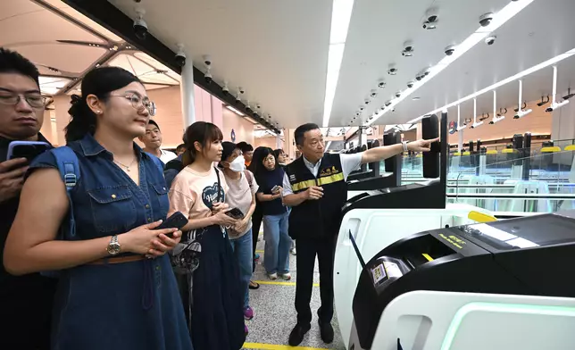 保安局10月4日舉辦社區體驗日，邀請全港各區的市民實地參觀和遊覽皇崗口岸聯檢大樓港方口岸區。圖示入境事務處人員在5樓離境大堂介紹「合作查驗」自助通道的運作，讓參加者進一步了解「合作查驗、一次放行」的嶄新通關模式。資料圖片